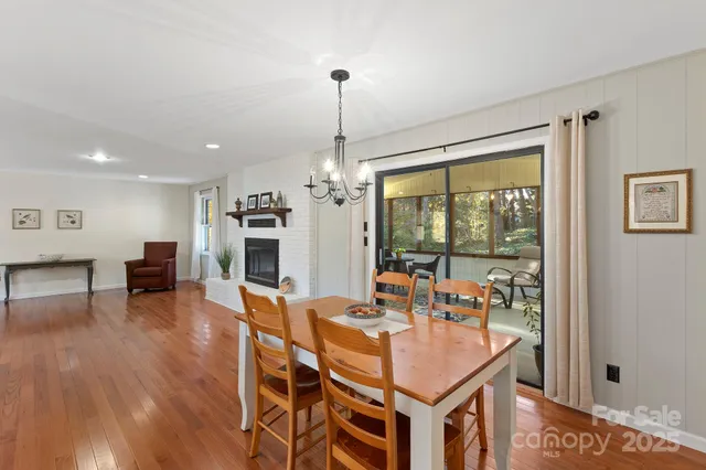 a dining room with furniture a chandelier and wooden floor