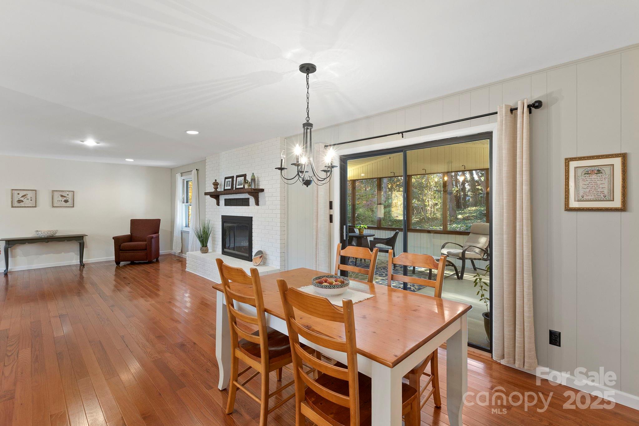 228 Raintree Drive Hendersonville, NC 28791 - Photo 14 of 37 a dining room with furniture a chandelier and wooden floor