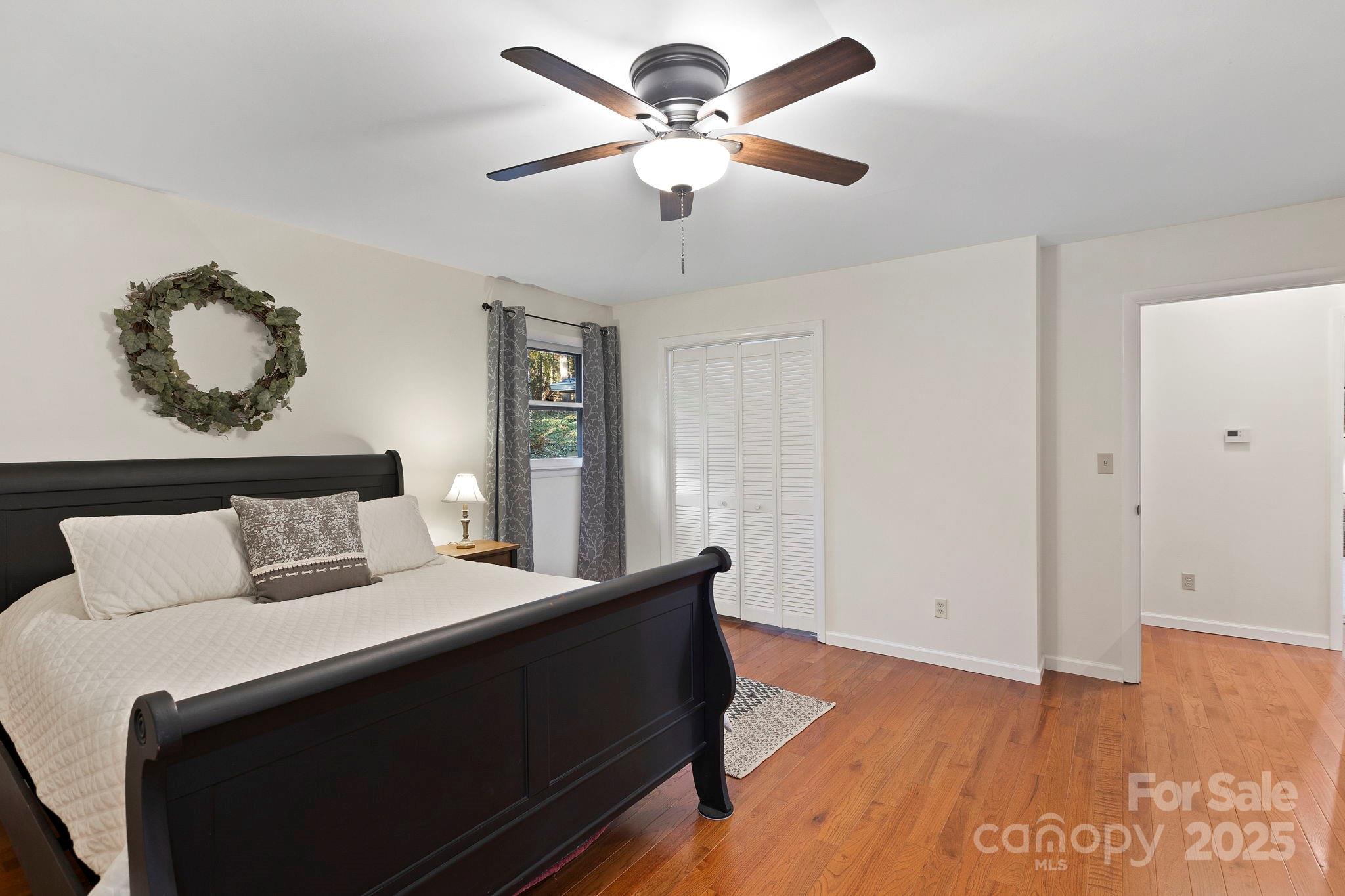 228 Raintree Drive Hendersonville, NC 28791 - Photo 21 of 37 a bedroom with a bed and a ceiling fan