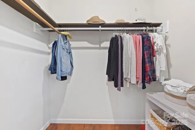 a view of walk in closet with clothes and shoes