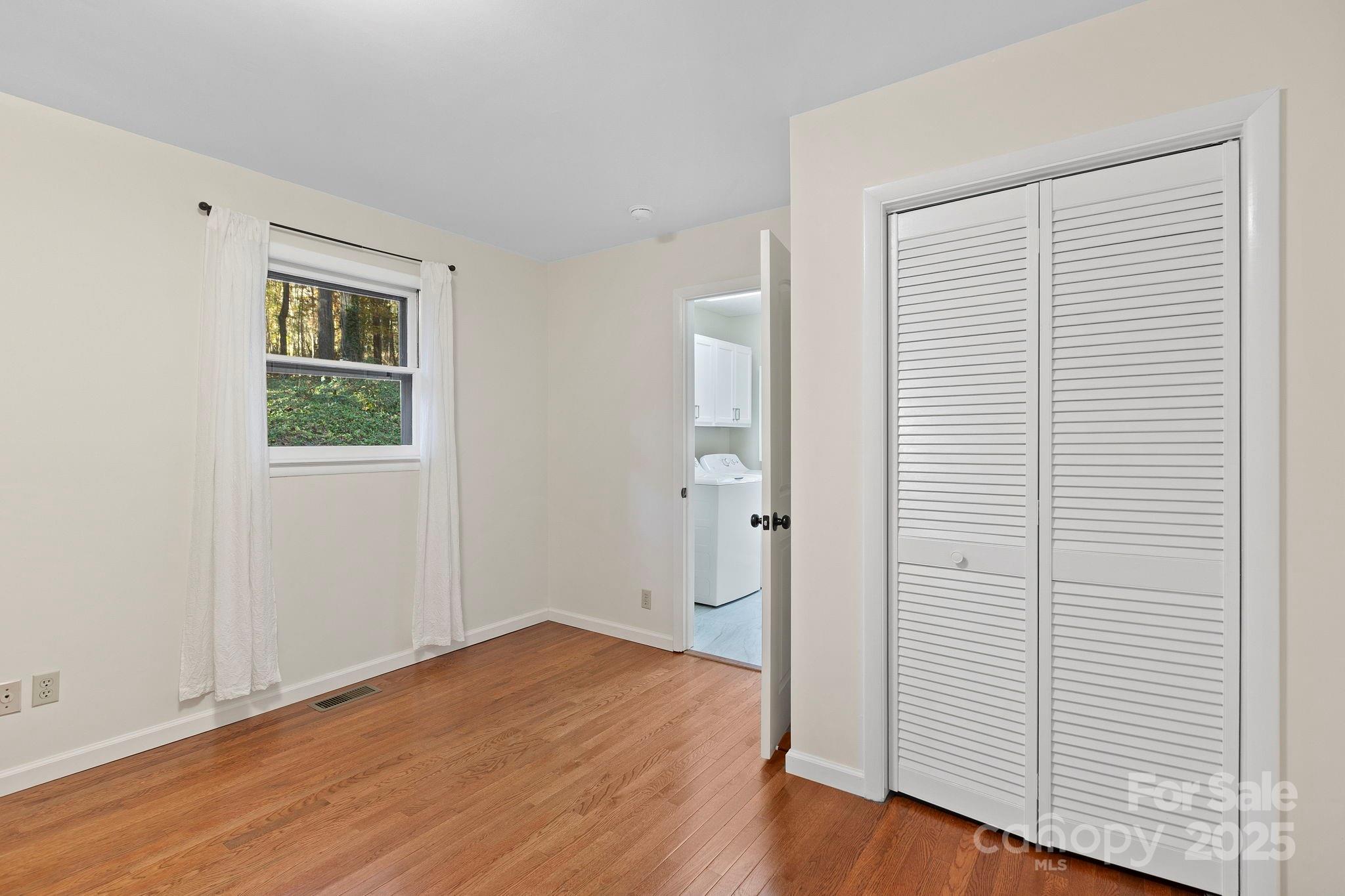 228 Raintree Drive Hendersonville, NC 28791 - Photo 30 of 37 an empty room with wooden floor and windows