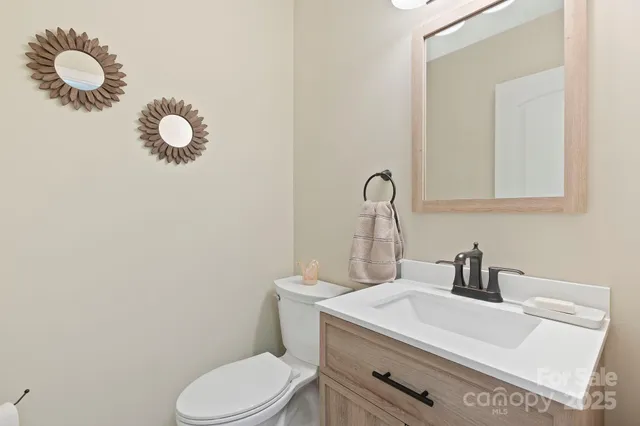 a bathroom with a sink mirror vanity and toilet