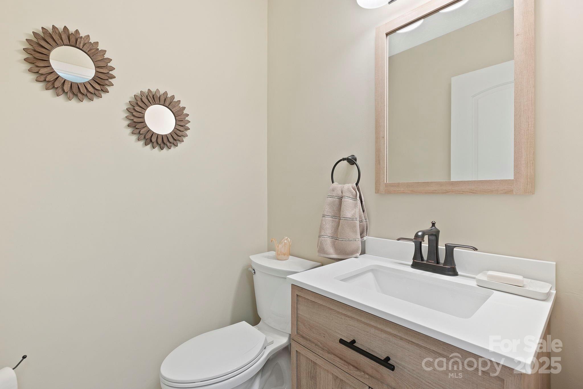 228 Raintree Drive Hendersonville, NC 28791 - Photo 32 of 37 a bathroom with a sink mirror vanity and toilet
