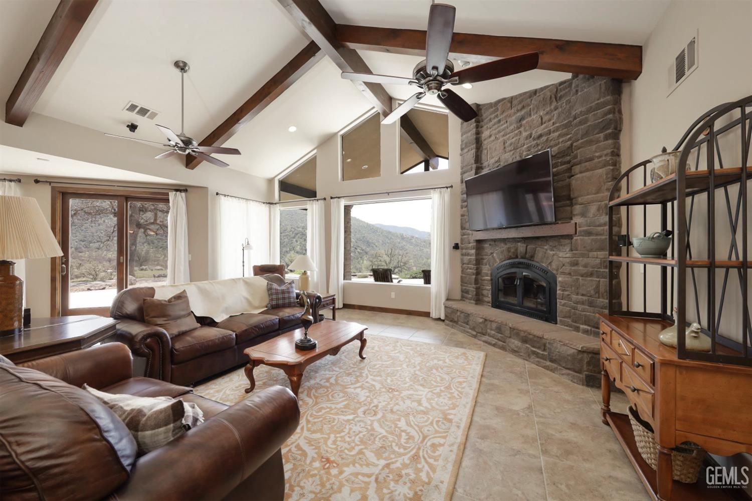Undisclosed Address Bakersfield, CA 93308 - Photo 11 of 51 a living room with furniture a fireplace and a ceiling fan