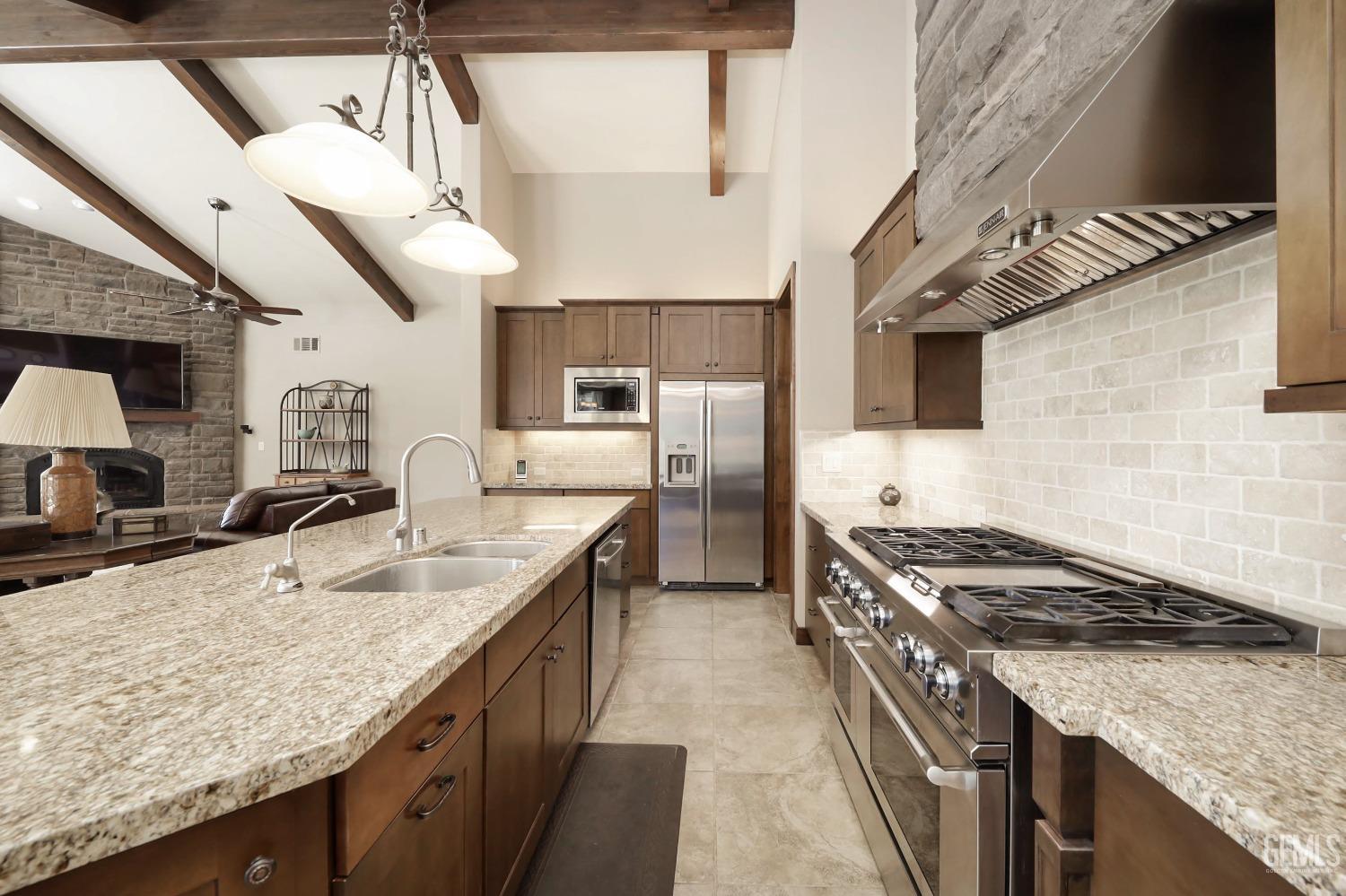 Undisclosed Address Bakersfield, CA 93308 - Photo 14 of 51 a kitchen with stainless steel appliances granite countertop a sink a stove and a wooden floors