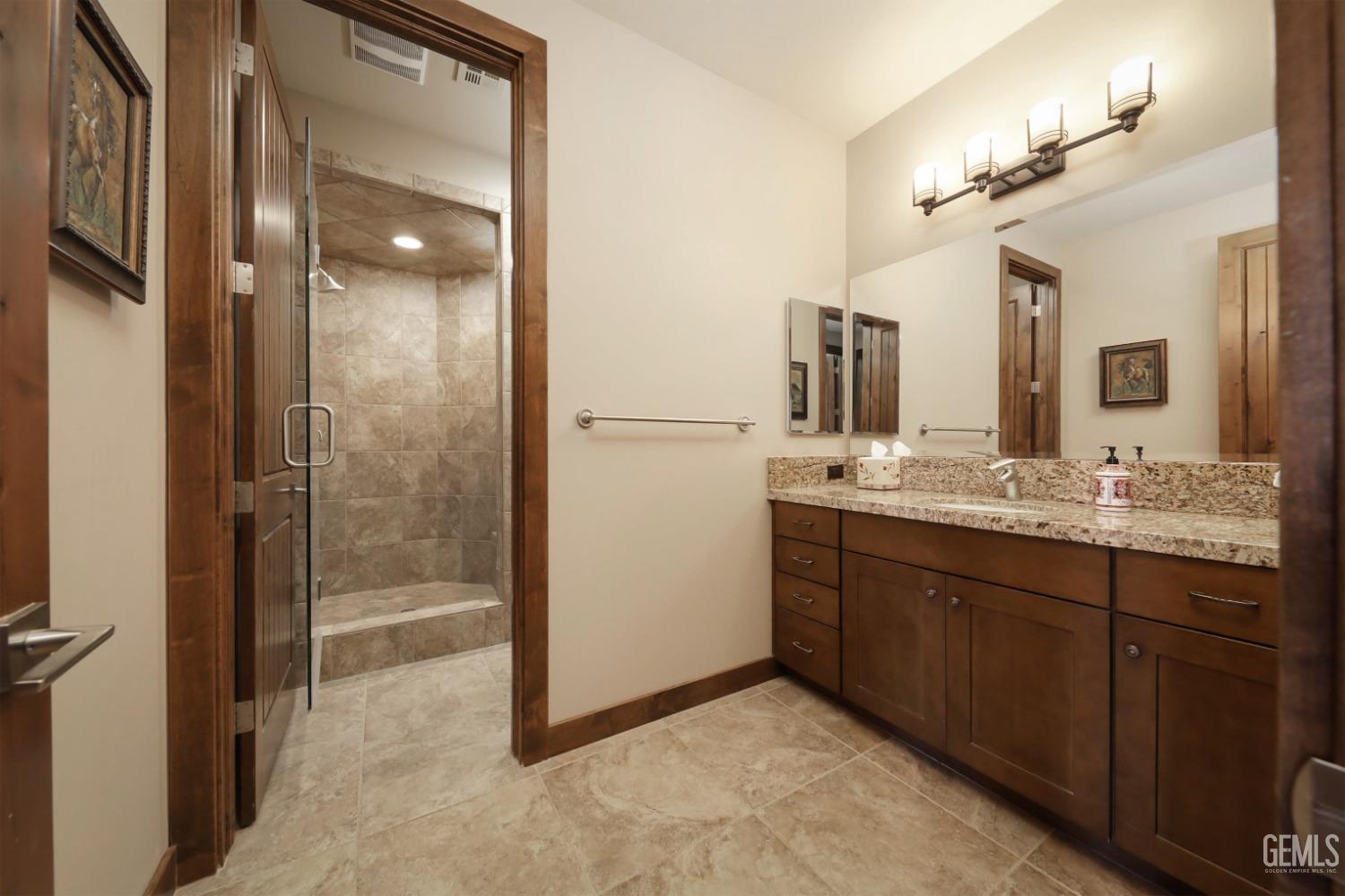Undisclosed Address Bakersfield, CA 93308 - Photo 24 of 51 a bathroom with a granite countertop sink mirror and shower