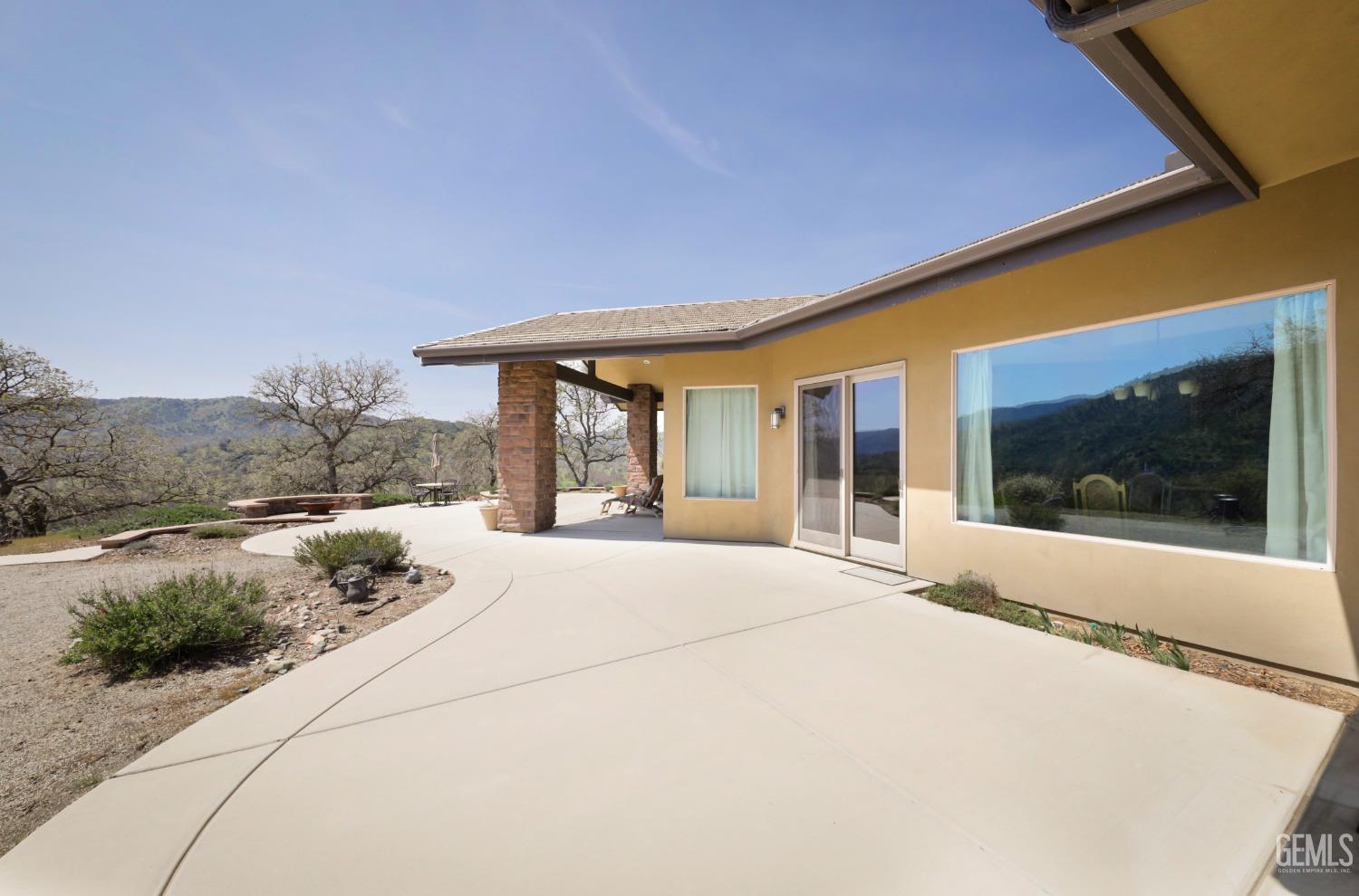 Undisclosed Address Bakersfield, CA 93308 - Photo 32 of 51 a front view of a house with a yard and potted plants