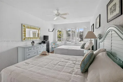 a spacious bedroom with a large bed and ceiling fan