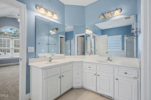 a spacious bathroom with double sink and a mirror