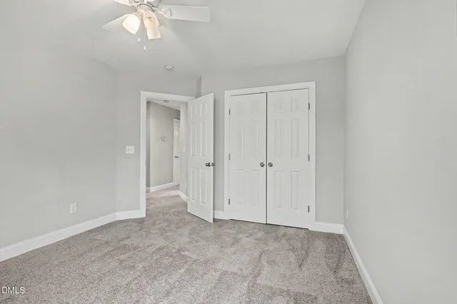 an empty room with a chandelier fan