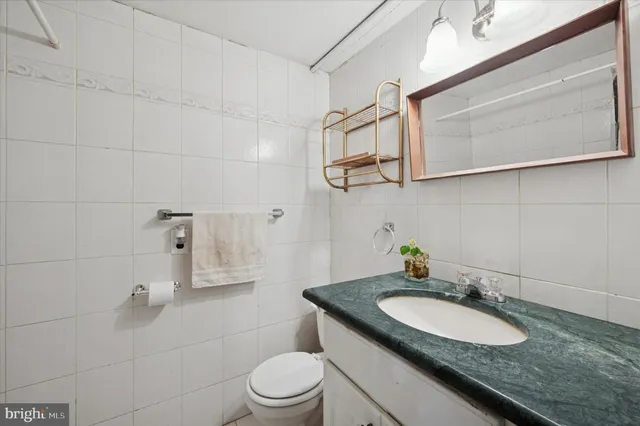 a bathroom with a granite countertop sink a toilet and shower