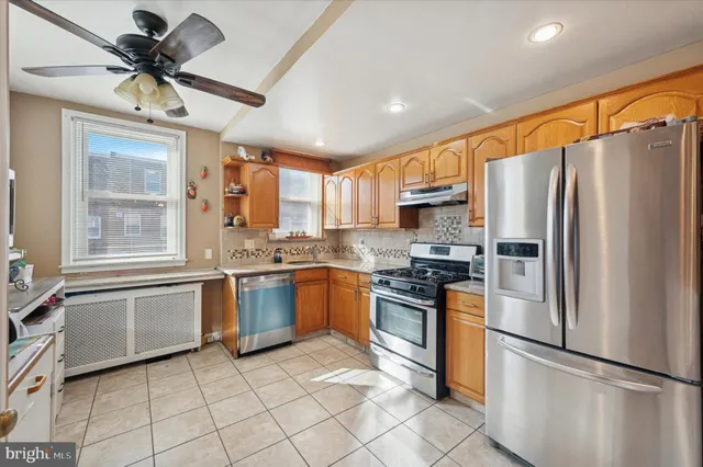 a kitchen with granite countertop stainless steel appliances a refrigerator cabinets and a sink