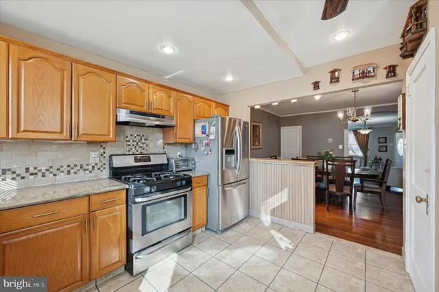 a kitchen with stainless steel appliances granite countertop a refrigerator and a stove top oven