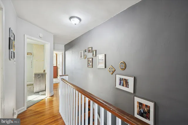 a view of a hallway with entryway and wooden floor