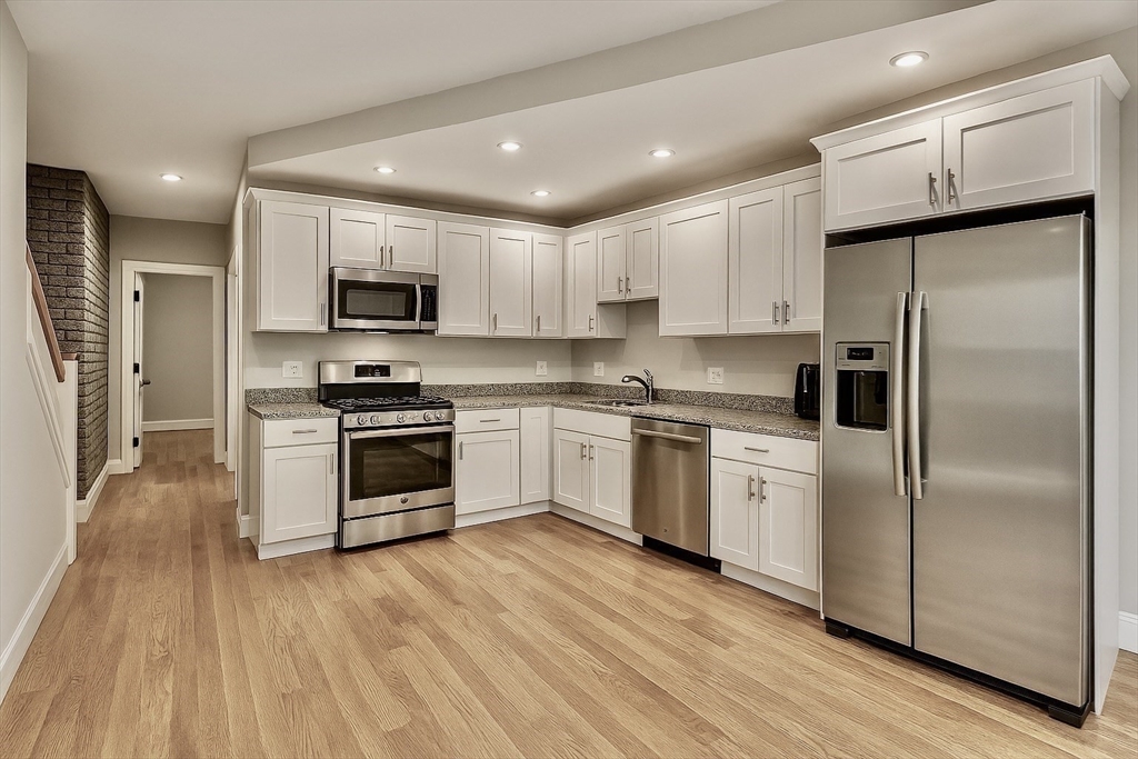 129 Sutherland Road Boston, MA 02135 - Photo 2 of 12 a kitchen with stainless steel appliances a refrigerator sink and stove top oven