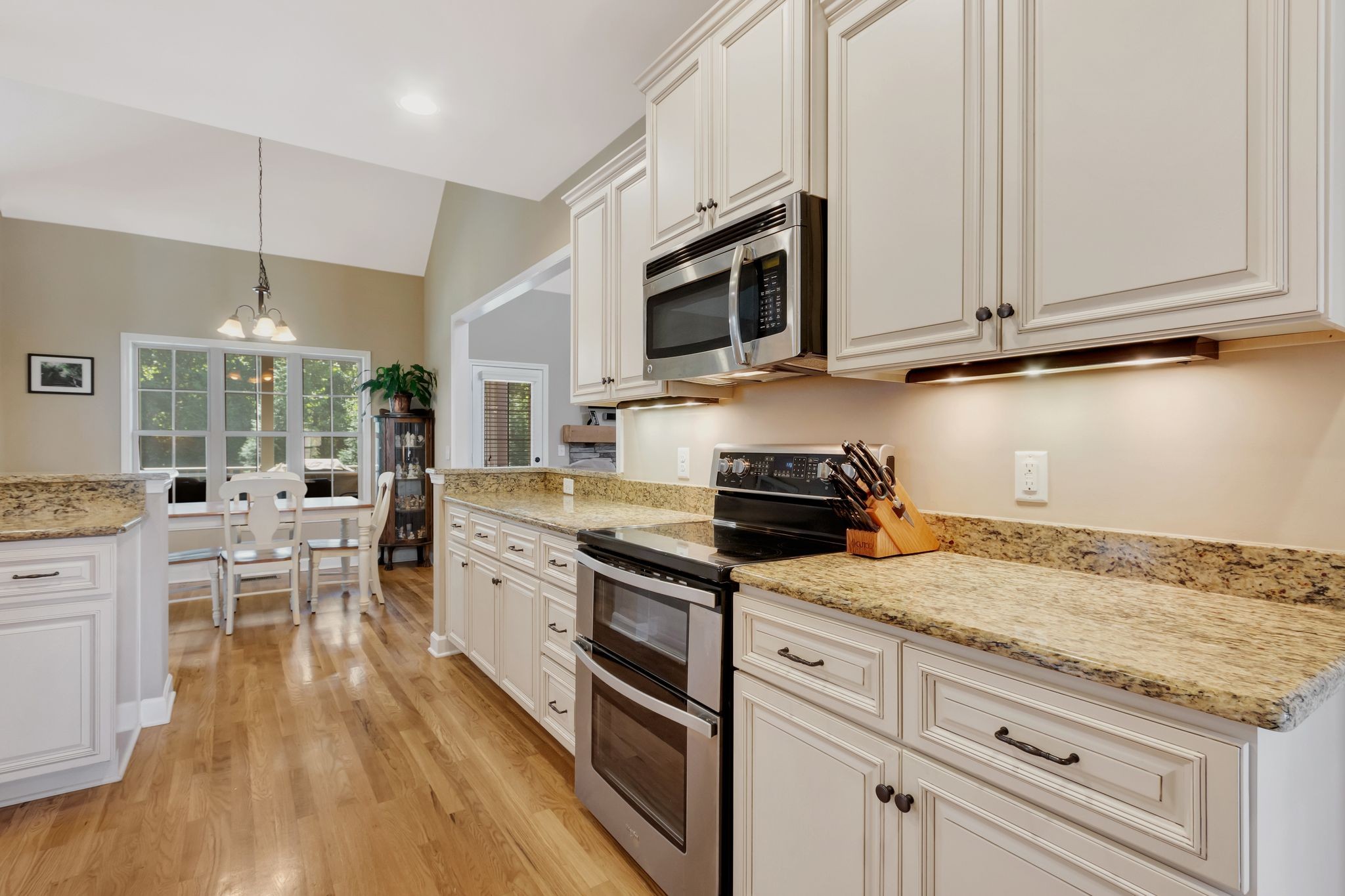 1004 Rudder Drive Spring Hill, TN 37174 - Photo 17 of 50 a kitchen with stainless steel appliances granite countertop a stove top oven a sink dishwasher a dining table and chairs with wooden floor