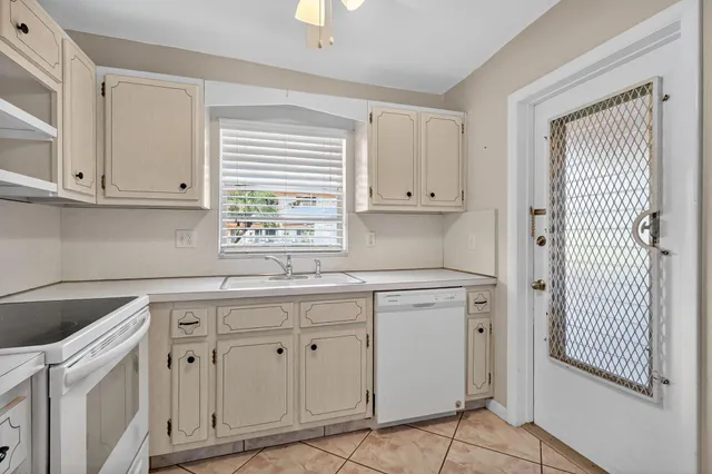 a kitchen with white cabinets and sink