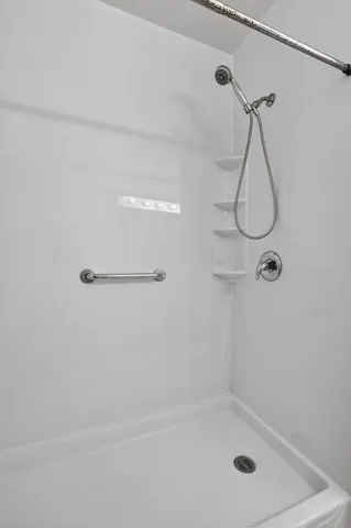 a bathroom with a bath tub with a shower