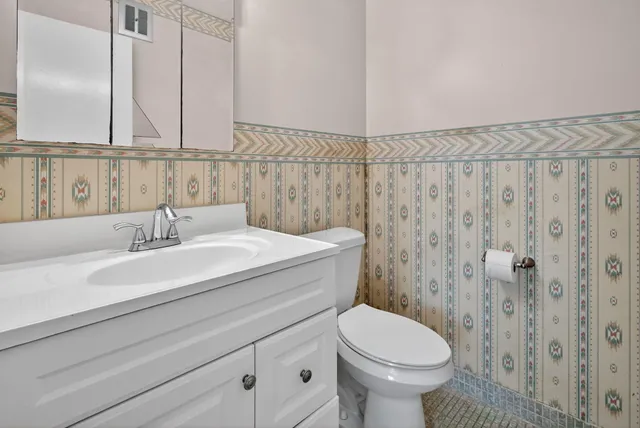 a bathroom with a sink a toilet and a mirror