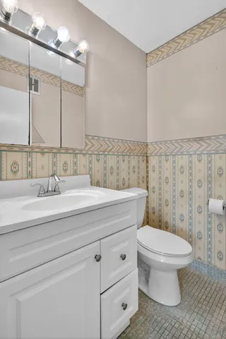 a bathroom with a sink a toilet and a mirror