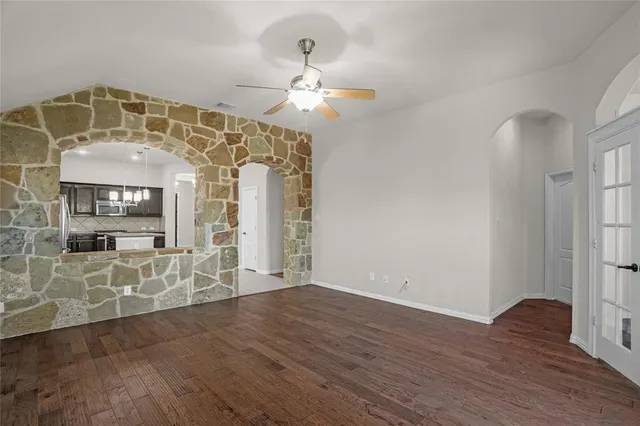 a view of a big room with wooden floor chandelier and windows
