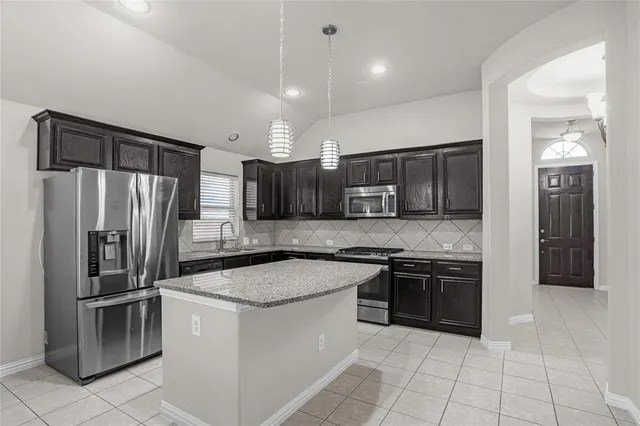 a kitchen with stainless steel appliances granite countertop a refrigerator stove and oven