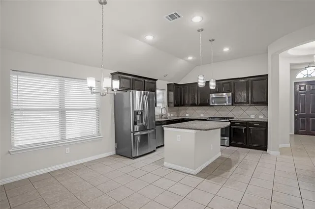 a kitchen with stainless steel appliances granite countertop a refrigerator and a sink