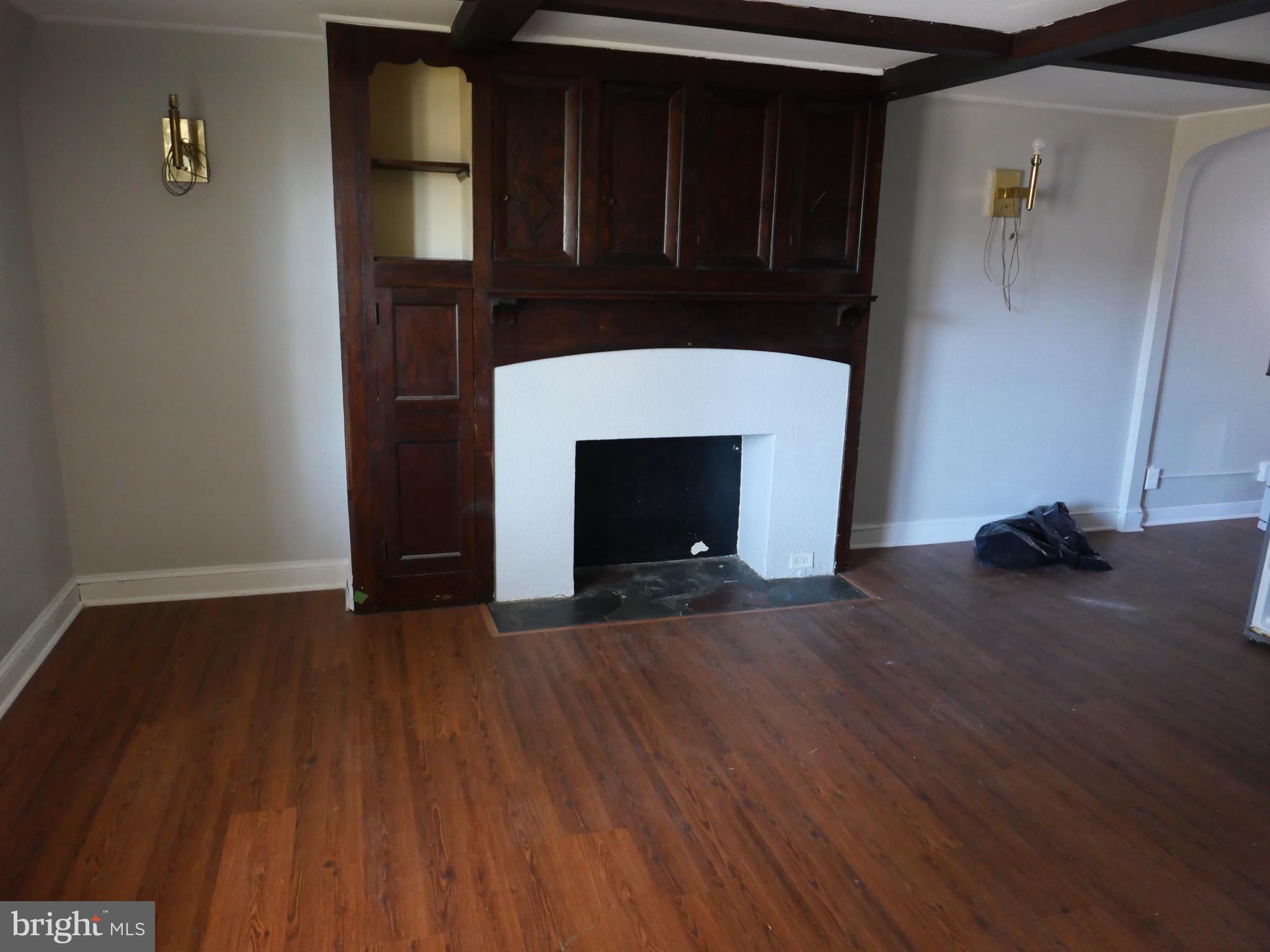 313 Hampden Road Upper Darby, PA 19082 - Photo 3 of 12 a view of an empty room with wooden floor and a fireplace