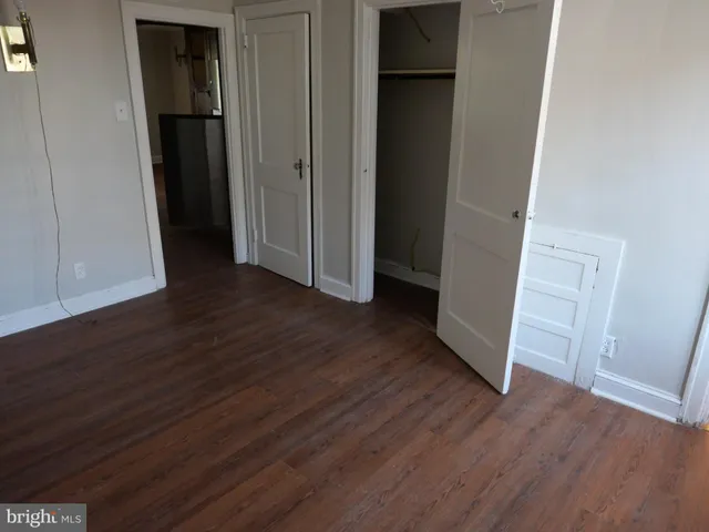 an empty room with wooden floor and closet