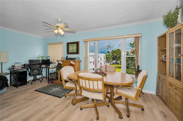a dining room with furniture and chandelier fan