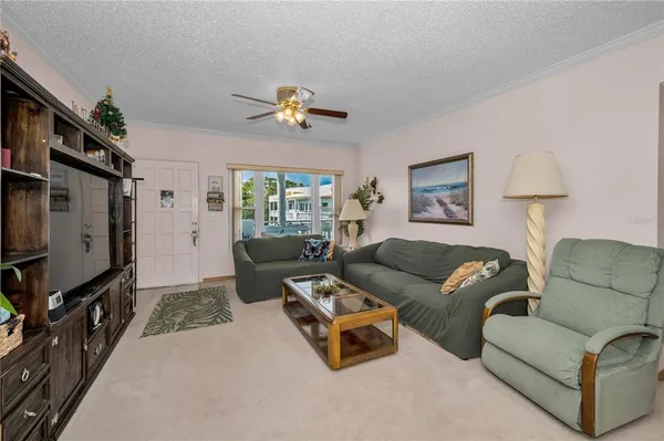 a living room with furniture ceiling fan and a window