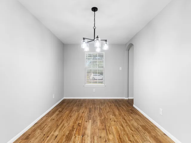 a view of a room with wooden floor ceiling fan and window