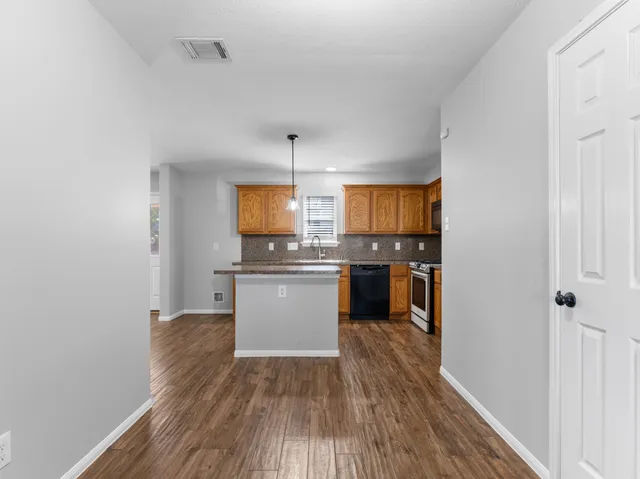 a kitchen with wooden floors and white cabinets