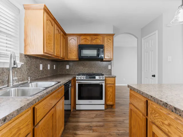 a kitchen with stainless steel appliances granite countertop a sink and a stove