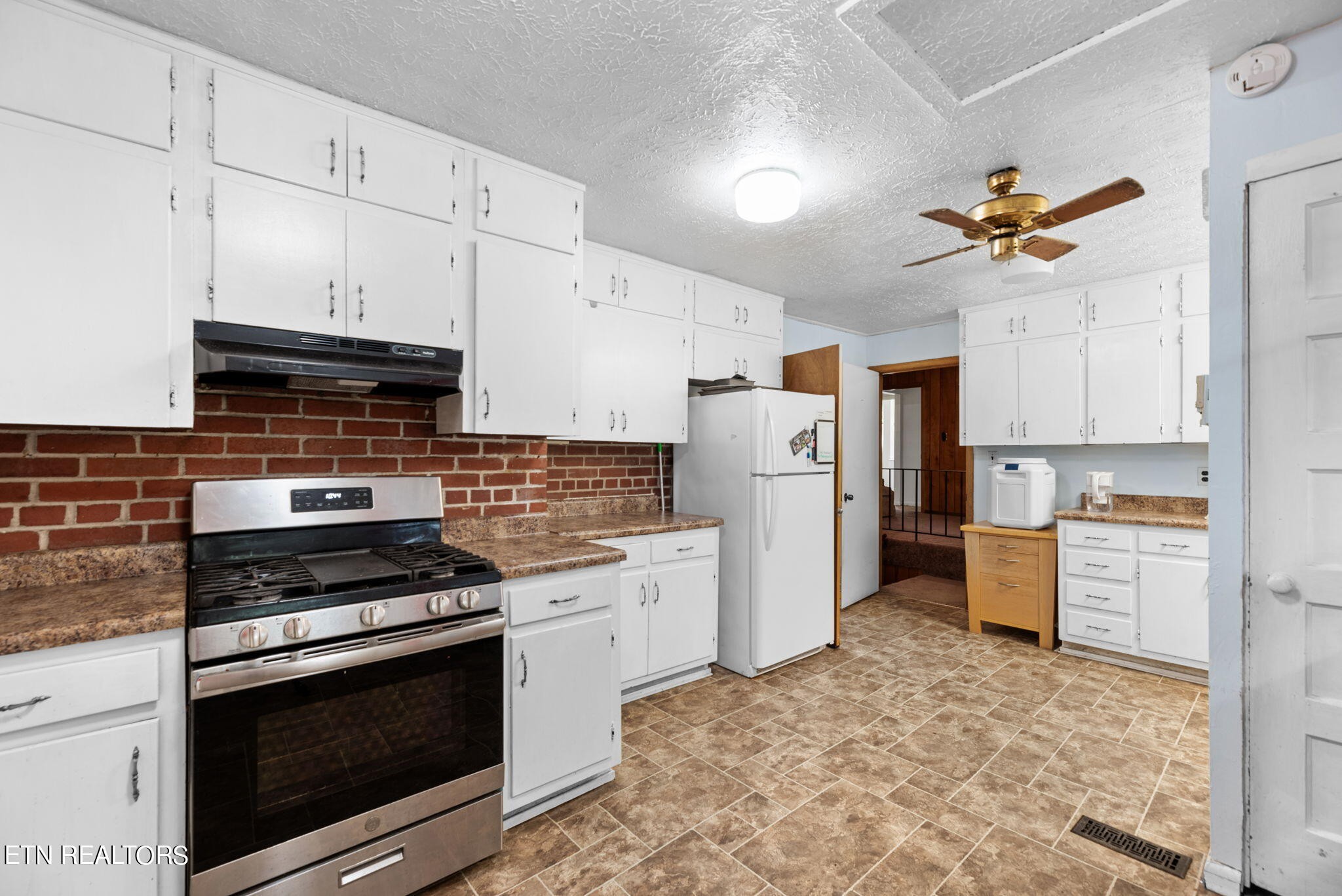 109 Venus Road Oak Ridge, TN 37830 - Photo 11 of 32 a kitchen with refrigerator a stove a microwave and cabinets
