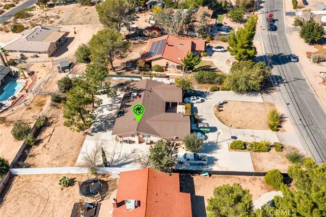 an aerial view of a house with a yard and seating space