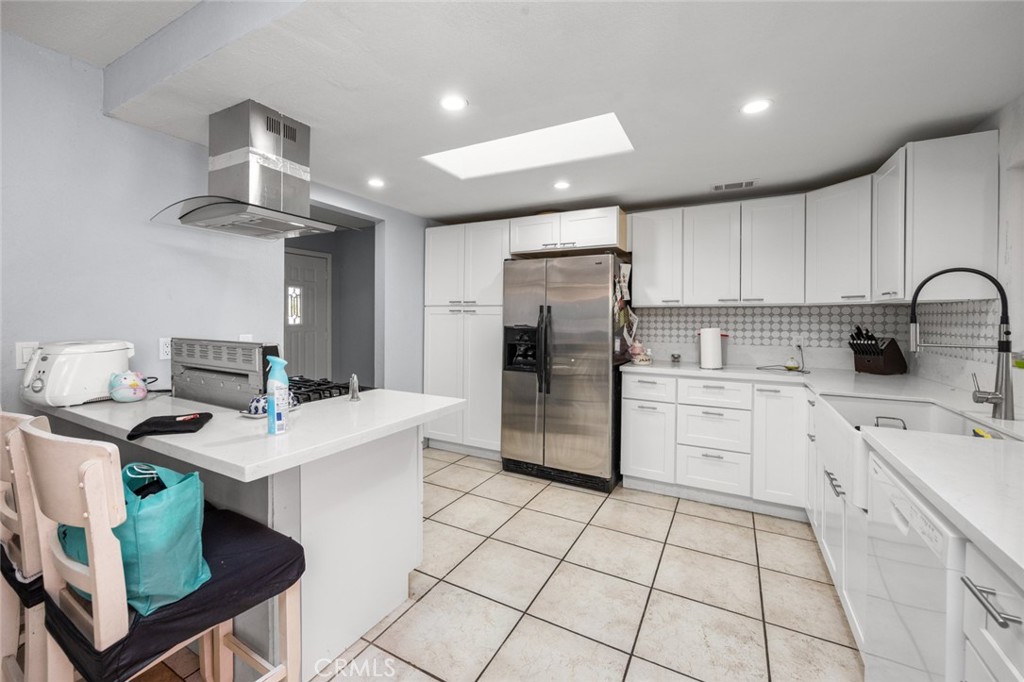 18629 Orange Street Hesperia, CA 92345 - Photo 12 of 46 a kitchen with kitchen island a stove a refrigerator and a sink with a dining table