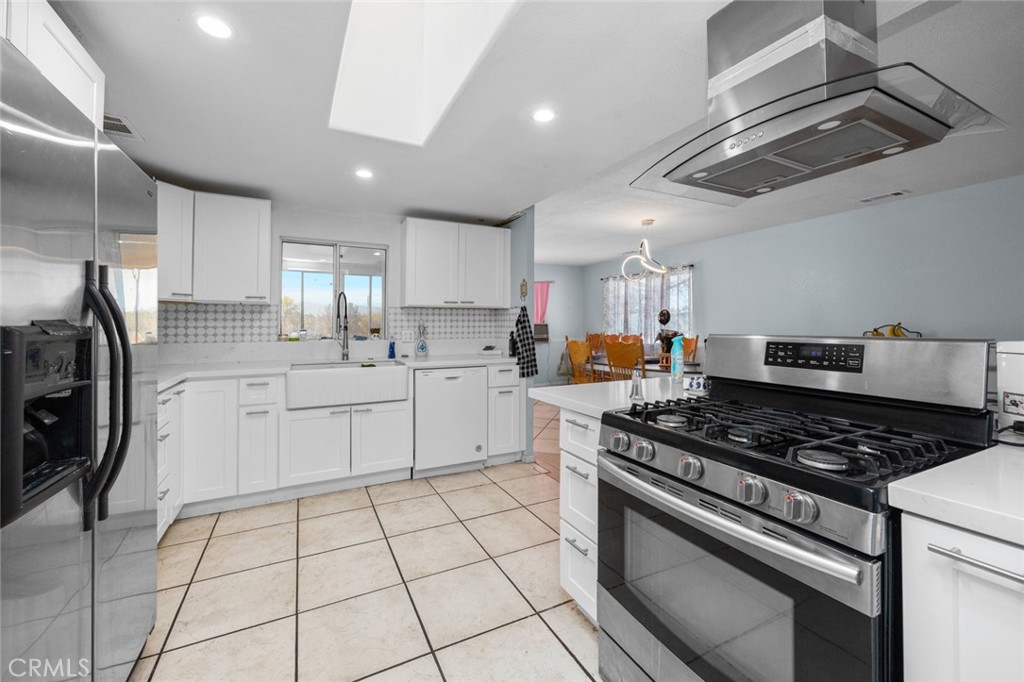 18629 Orange Street Hesperia, CA 92345 - Photo 14 of 46 a kitchen with stainless steel appliances granite countertop a stove a sink and a refrigerator