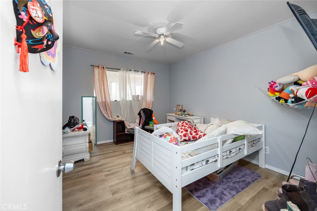18629 Orange Street Hesperia, CA 92345 - Photo 25 of 46 a bedroom with furniture and a chandelier fan