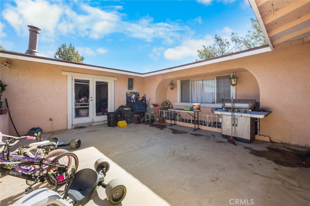 18629 Orange Street Hesperia, CA 92345 - Photo 31 of 46 a view of a patio with table and chairs and potted plants