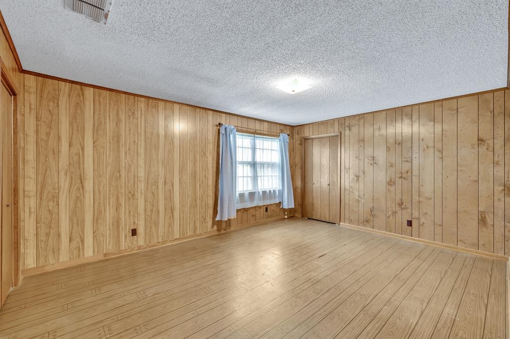 1368 County Road 2206 Rusk, TX 75785 - Photo 19 of 32 an empty room with wooden floor and windows with curtains