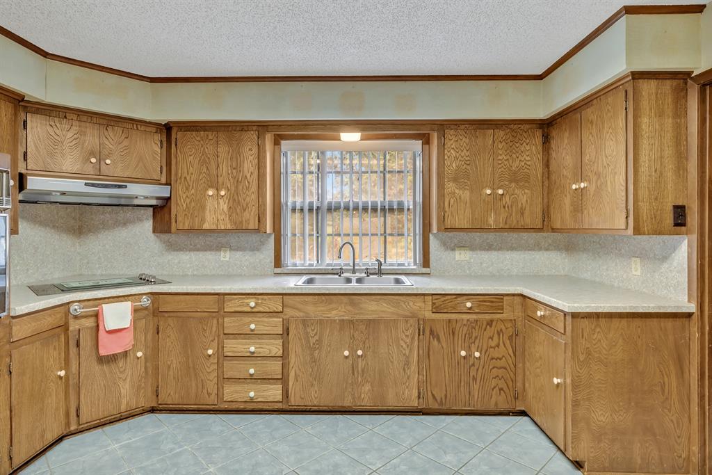 1368 County Road 2206 Rusk, TX 75785 - Photo 10 of 32 a kitchen with cabinets a sink and wooden cabinets
