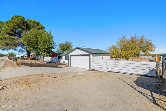 a tree in front of a white house