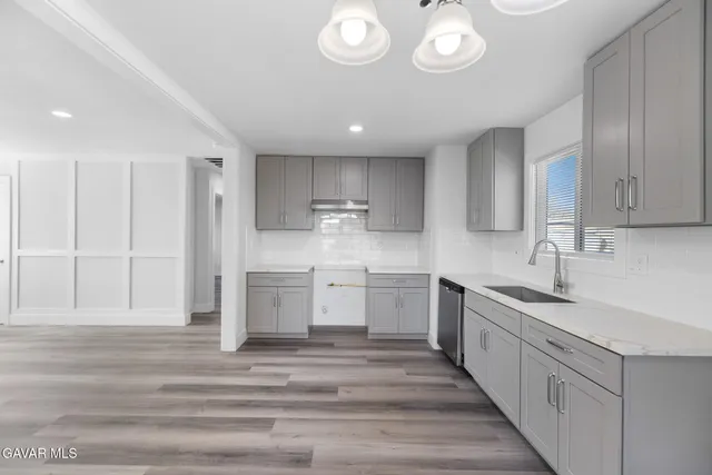 a large kitchen with a lot of counter space and wooden floor
