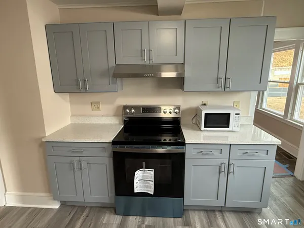 a kitchen with granite countertop white cabinets and a stove