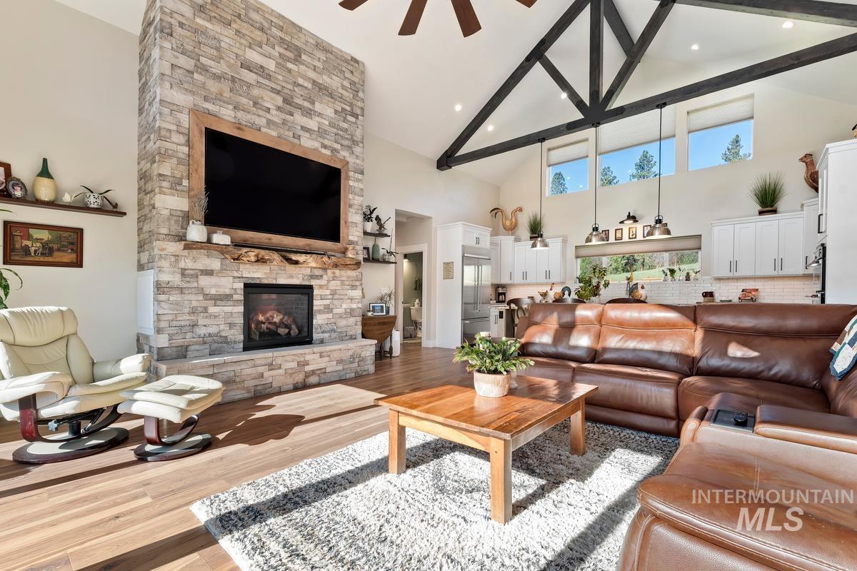21 Open Road Garden Valley, ID 83622 - Photo 3 of 49 Living room featuring a ceiling fan, a stone fireplace, wood finished floors, vaulted ceiling, and recessed lighting