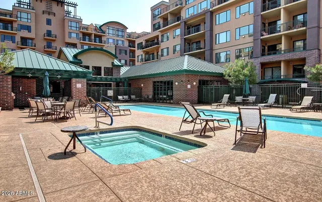 a living room with furniture a clock on wall and a large window