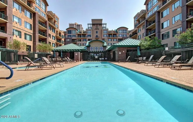a patio with table and chairs and potted plants