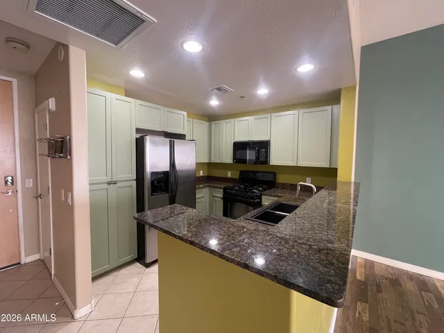 a kitchen with kitchen island granite countertop stainless steel appliances and a counter top