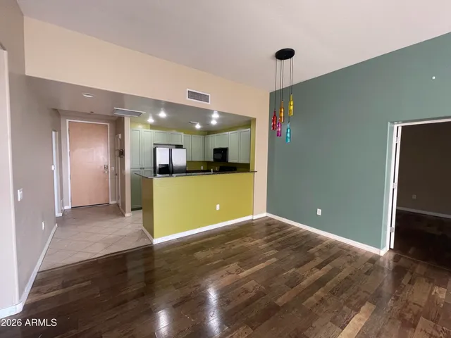 a view of a livingroom with wooden floor and kitchen space with a sink
